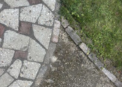 Mozaiekbestrating van hergebruikte betontegels met grasrand